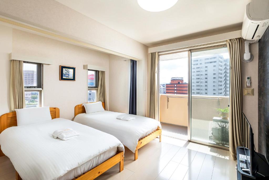 福冈Tenjin Minami San Ban Kan的带大窗户的客房内的两张床