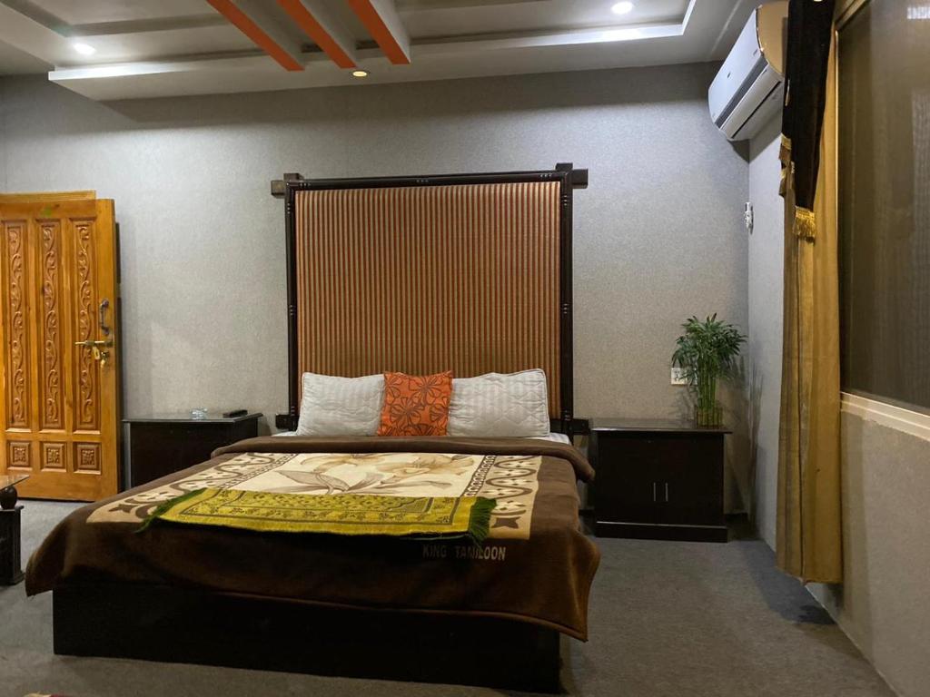 穆扎法拉巴德Kashmir lodge的一间卧室配有一张带大床头板的床