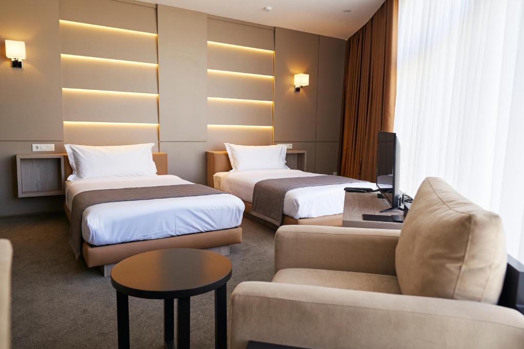 比什凯克City Stay Bishkek的酒店客房,设有两张床和一张沙发