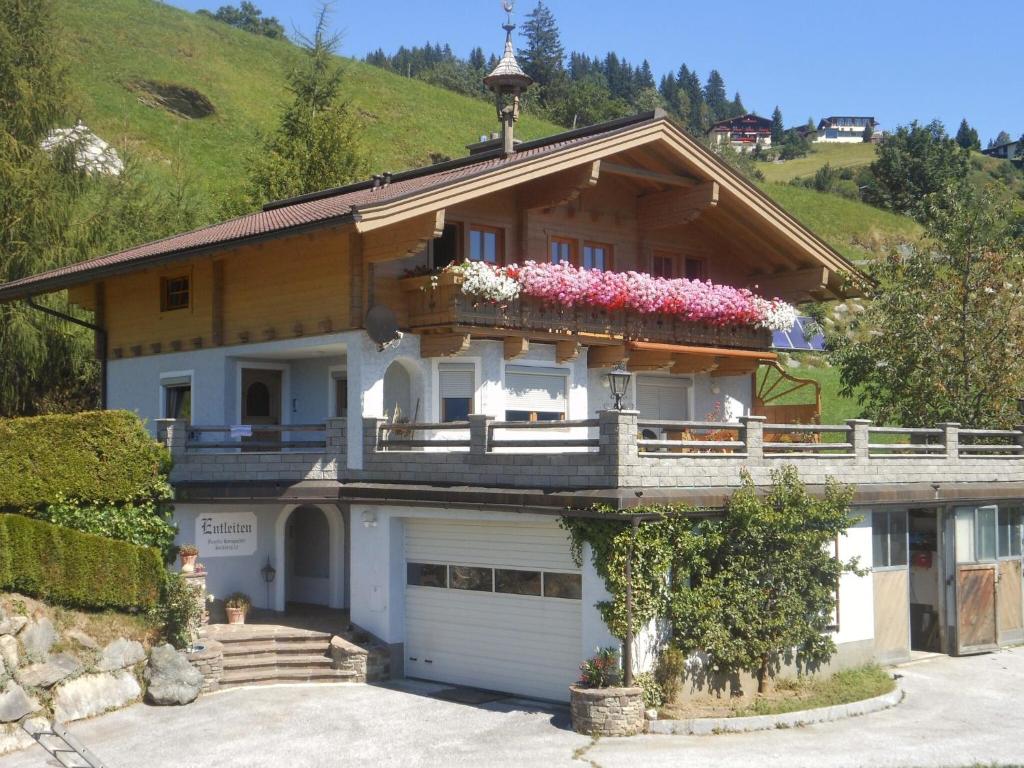 平茨高谷地霍勒尔斯巴赫Sunlit Apartment near Ski Area in Hollersbach im Pinzgau的一座房子,阳台上种着鲜花