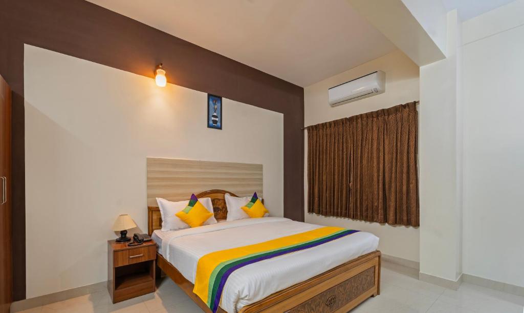 哥印拜陀Itsy By Treebo - Sri Mani'S Residency, Coimbatore Airport的一间卧室配有一张特大号床和色彩缤纷的枕头