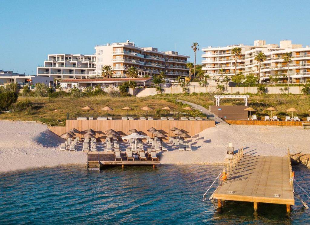伊兹密尔Casa De Playa Luxury Hotel & Beach的海滩上带椅子和遮阳伞的码头