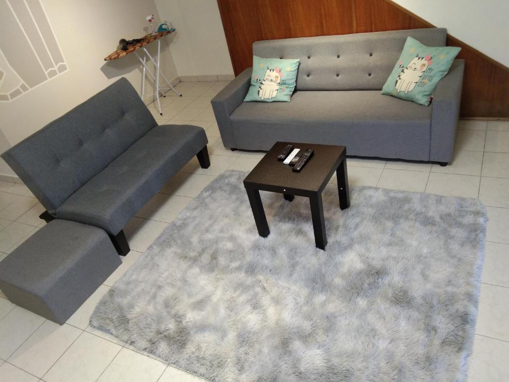 怡保QQ Homestay的客厅配有两张沙发和一张咖啡桌