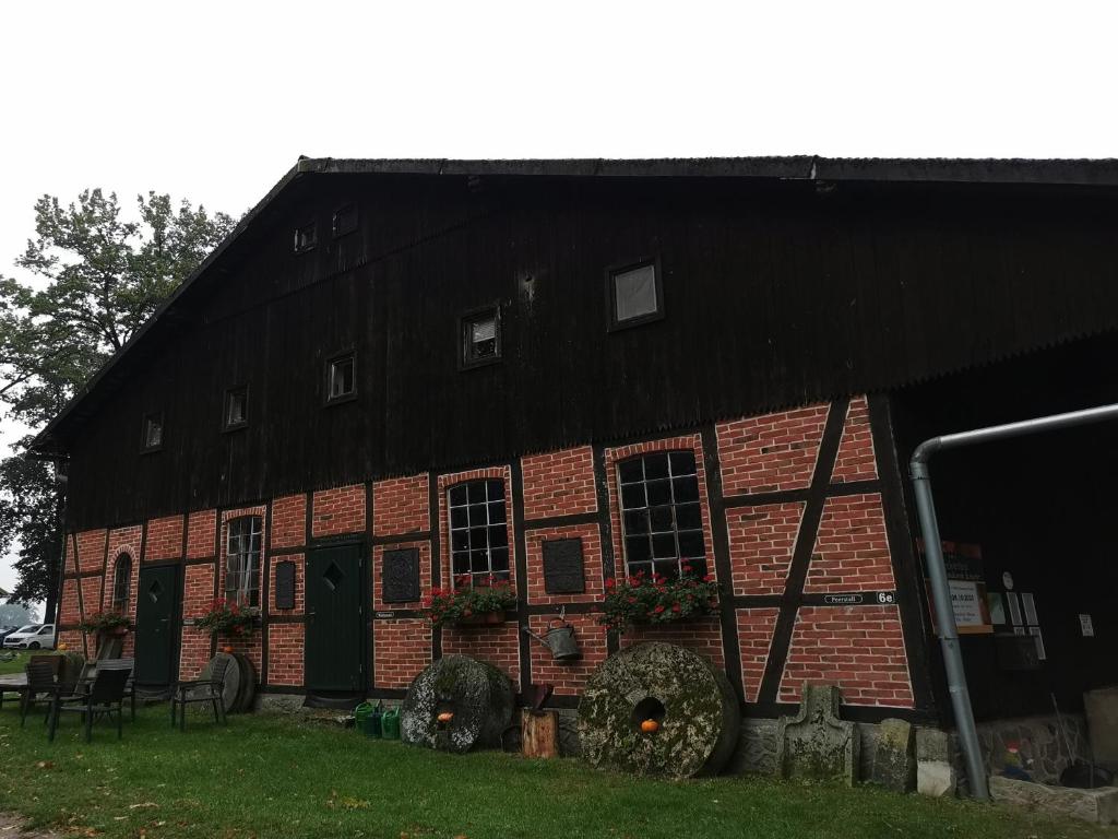BommelsenBeekenhof Ferienwohnung für Monteure的黑色屋顶红砖谷仓
