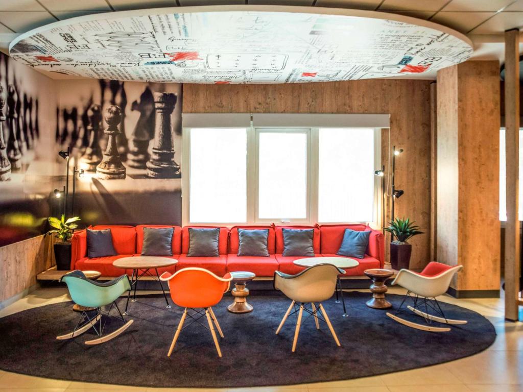 亚松森ibis Asuncion的客厅配有红色的沙发和椅子