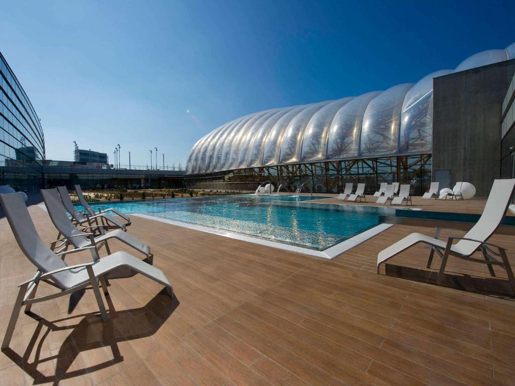 内顿斯内登维塔公园全季酒店的一个带椅子的游泳池以及体育场