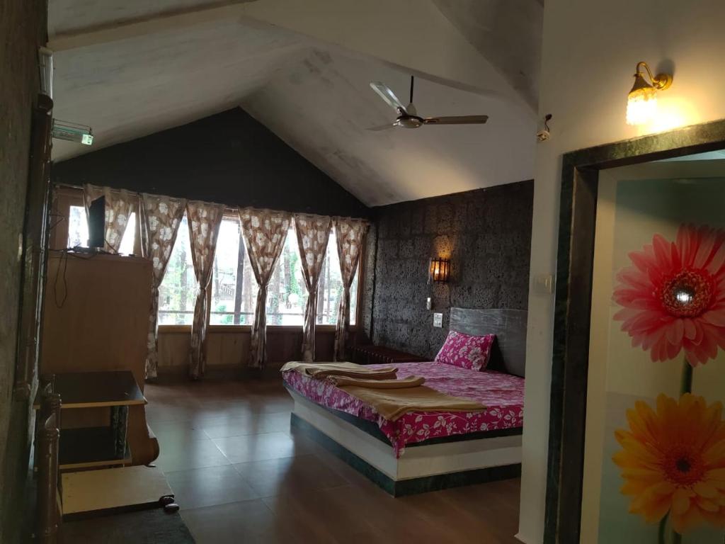 BhogweVamoose Manali Beach Resort的一间卧室配有一张带粉色床单的床和一扇窗户。