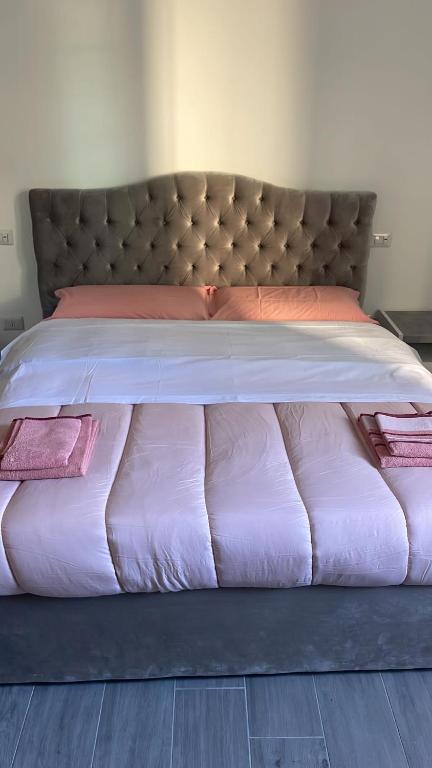 托尔托纳Appartamento Tortona的一张大床,配有粉红色的床单和粉红色的枕头