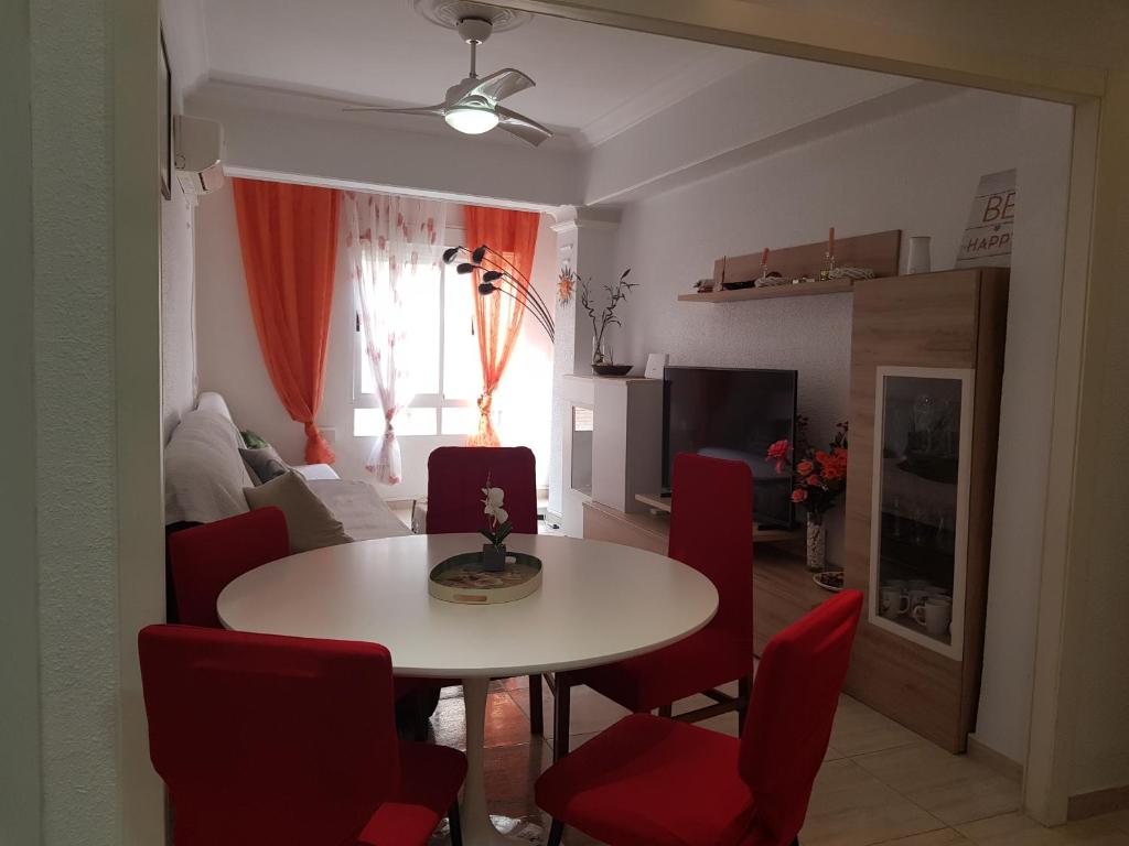 格拉德卡斯特利翁BRIZO SUITES的客厅配有桌子和红色椅子
