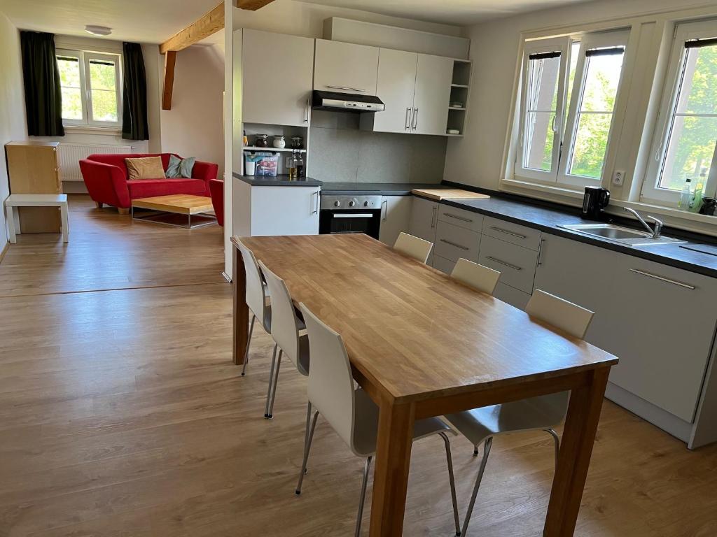 HoÅ¡Å¥kaJelen的厨房以及带木桌和椅子的用餐室。