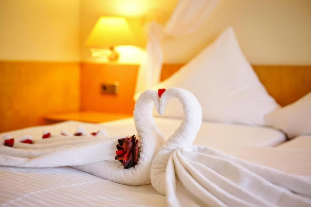 HarztorHotel und Restaurant Harzparadies的两个天鹅,被毛巾包在床上