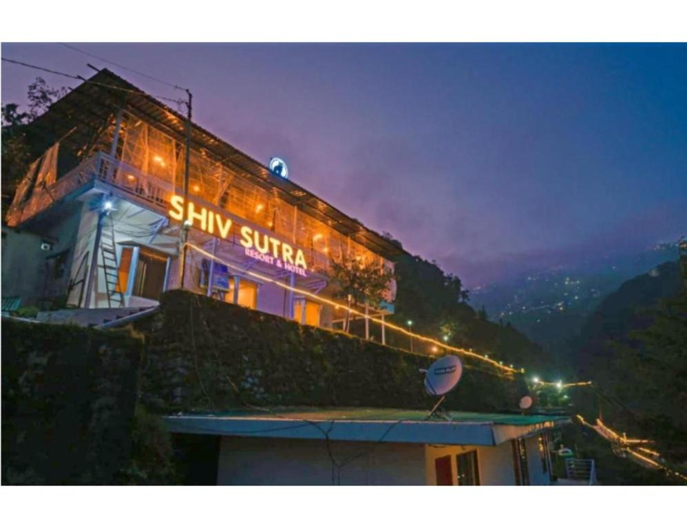 穆索里Shiv Sutra Resorts, Mussoorie的一座晚上有标志的建筑