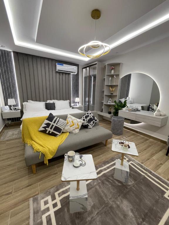 利雅德Riyadh modern studio的客厅配有床和2张桌子