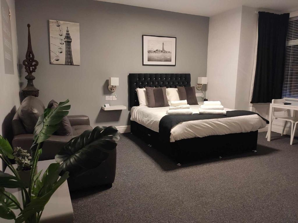 布莱克浦Q - Accomodation的一间卧室配有一张床、一张沙发和一把椅子