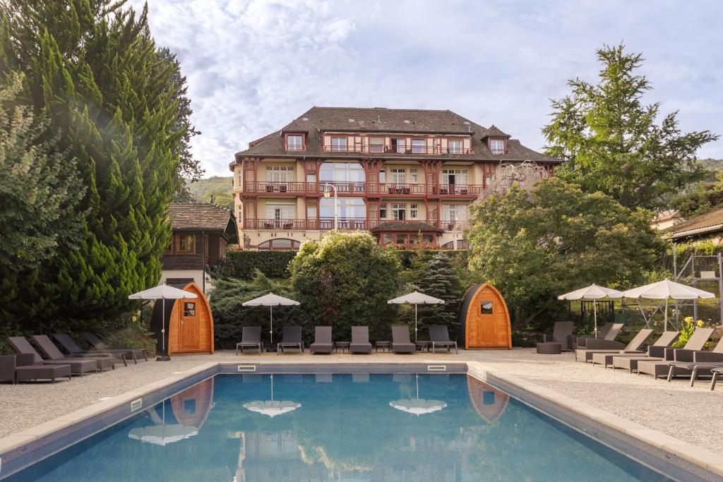 埃维昂莱班维尔尼亚酒店的大楼前设有游泳池的酒店