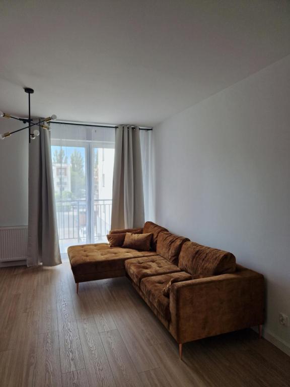 格鲁德柴兹Apartament Staromiejski Rapackiego 45的客厅设有一张棕色沙发,配有大窗户