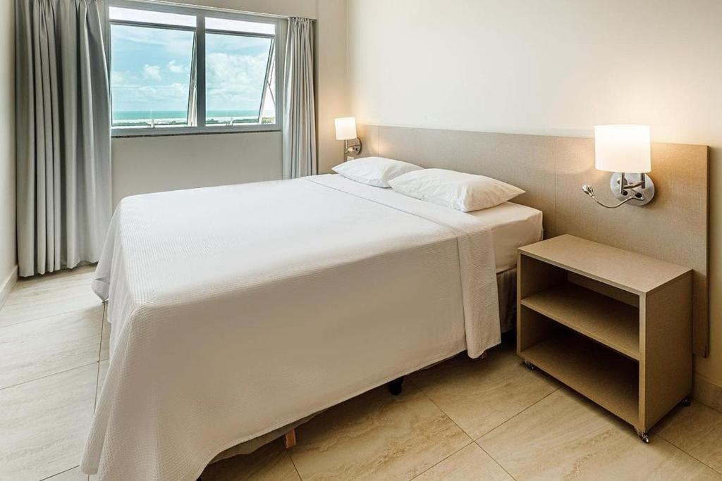 萨利诺波利斯Salinas Park Resort的卧室设有一张白色大床和一扇窗户。