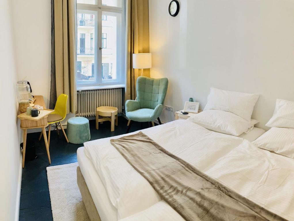 柏林Serviced Room im Herzen Berlin‘s的卧室配有白色的床和椅子