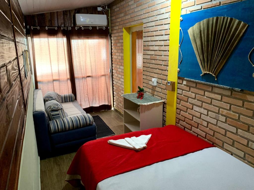 邦比尼亚斯Hostel Vento Leste的小房间设有一张床和一把椅子