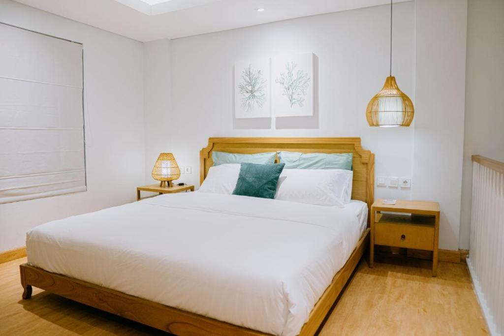 坎古Casa Amarta - Canggu的卧室配有一张白色大床和两盏灯。