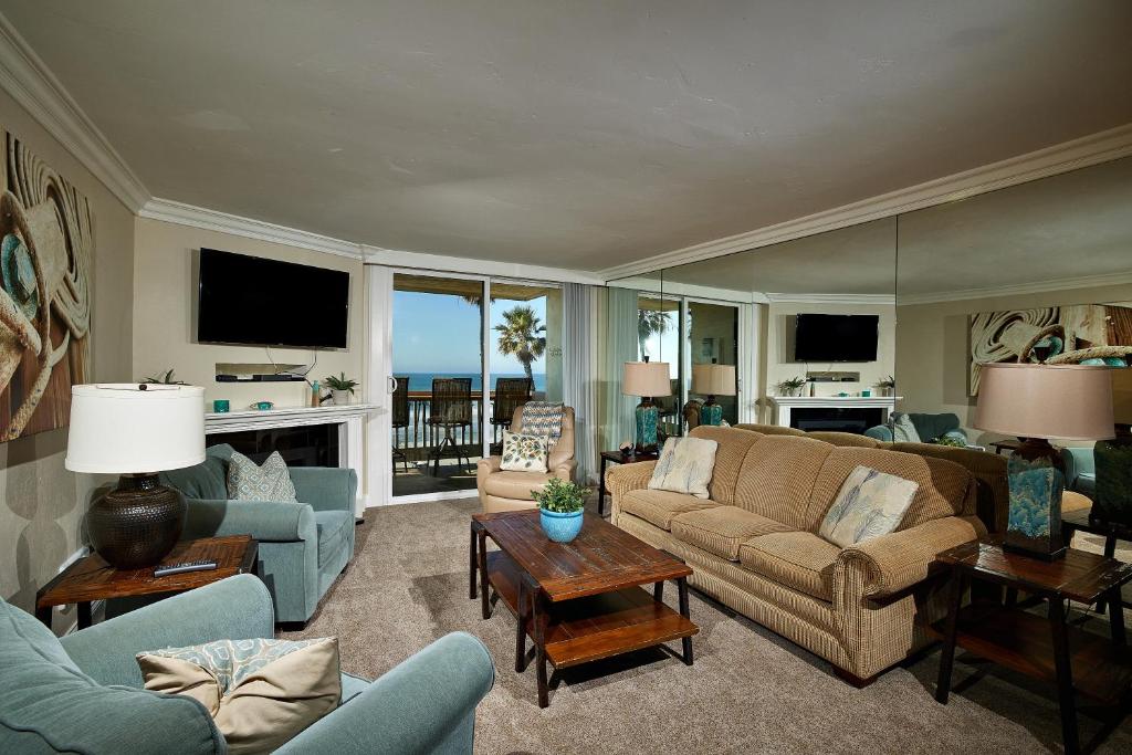 奥欣赛德Surf 'n Sand的带沙发、椅子和电视的客厅