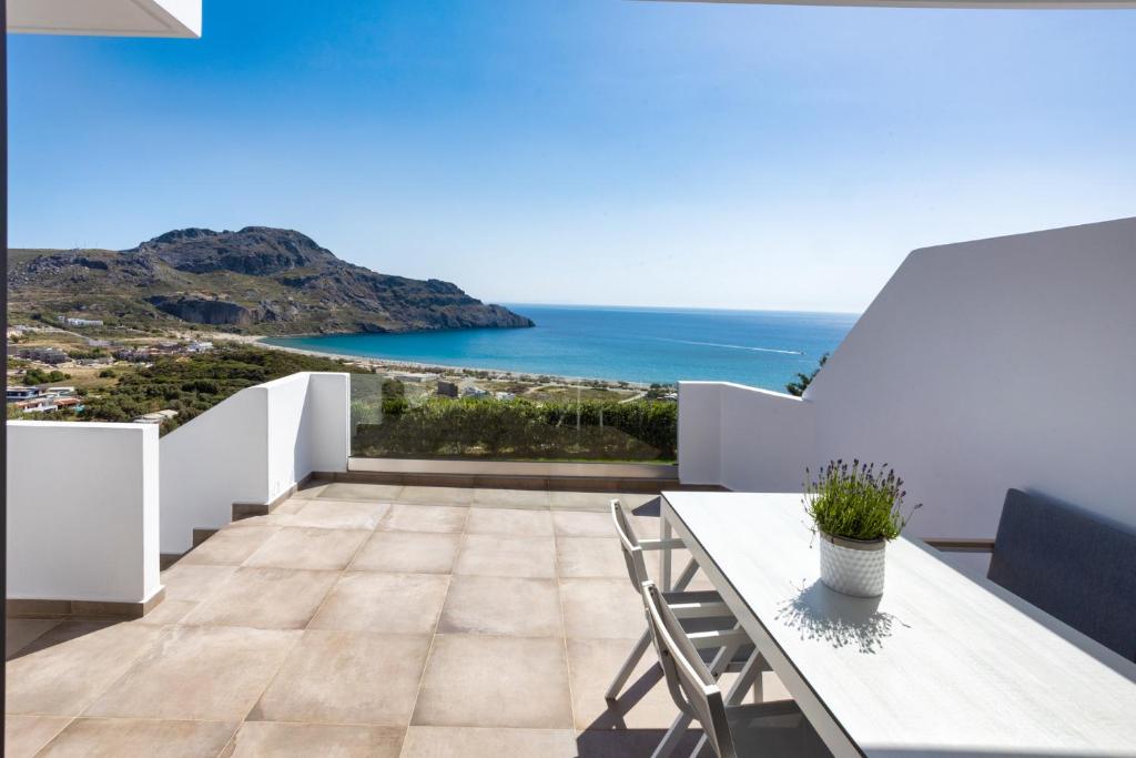 普拉基亚斯"Thea" Luxury Apartments with great View的阳台配有桌子,享有海景。