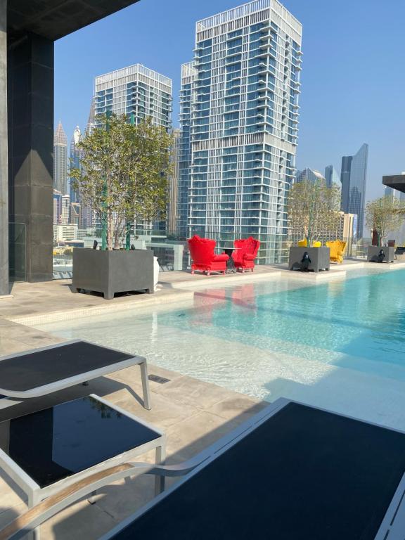 迪拜Modern 2BR and maid room with big terrace city walk的一座位于城市的游泳池,有高大的建筑