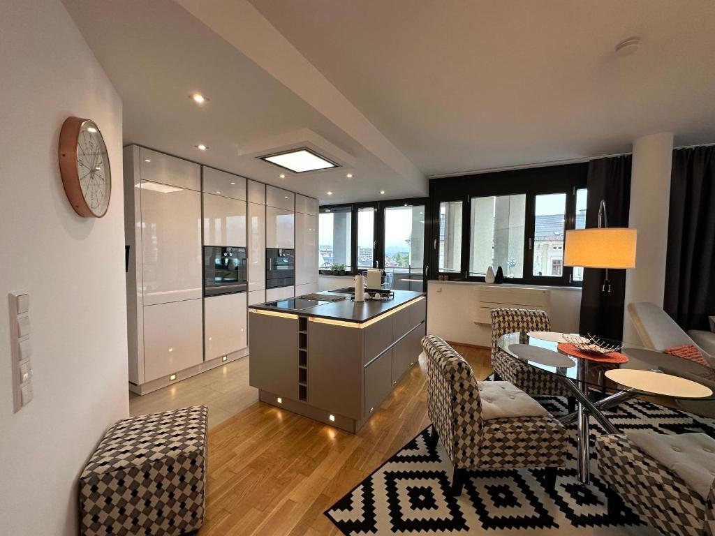 菲拉赫Luxury Apartment Villach City的厨房以及带桌椅的起居室。