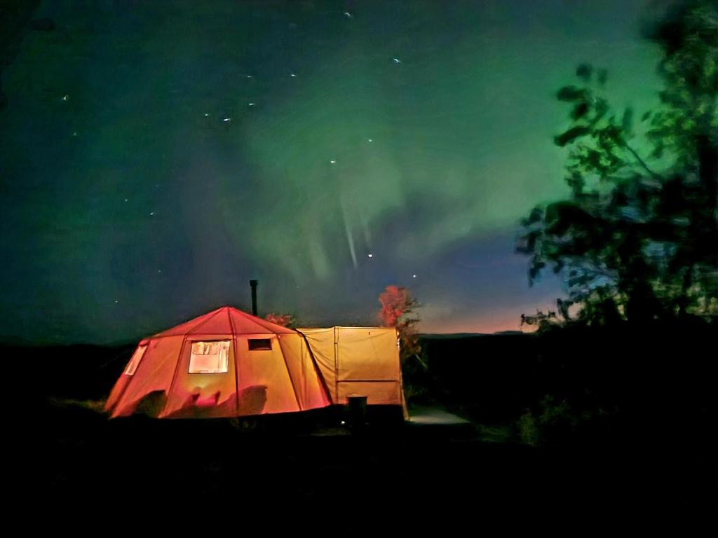 阿尔塔Finnmark Glamping的星空下的红色和白色帐篷