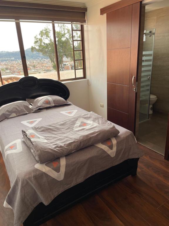 昆卡Evangelio Inn的一间卧室设有一张床和一个玻璃淋浴间
