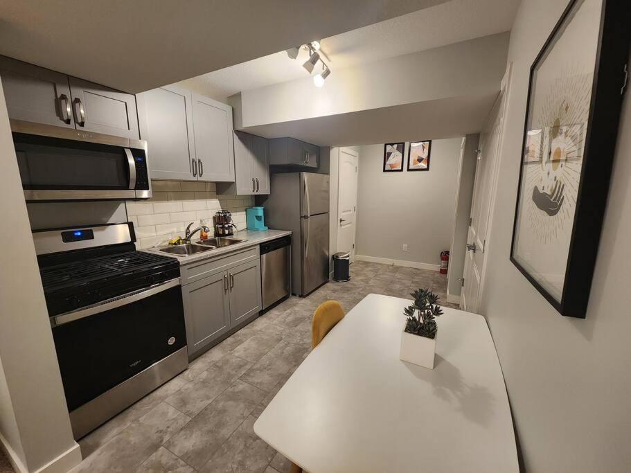 埃德蒙顿Deluxe 2 bedroom suite with*Netflix/Cable/Prime的厨房配有白色的桌子和炉灶。 顶部烤箱