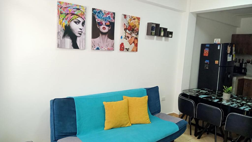 圣罗莎德卡瓦尔apartamento family的墙上挂着照片的房间的蓝色沙发