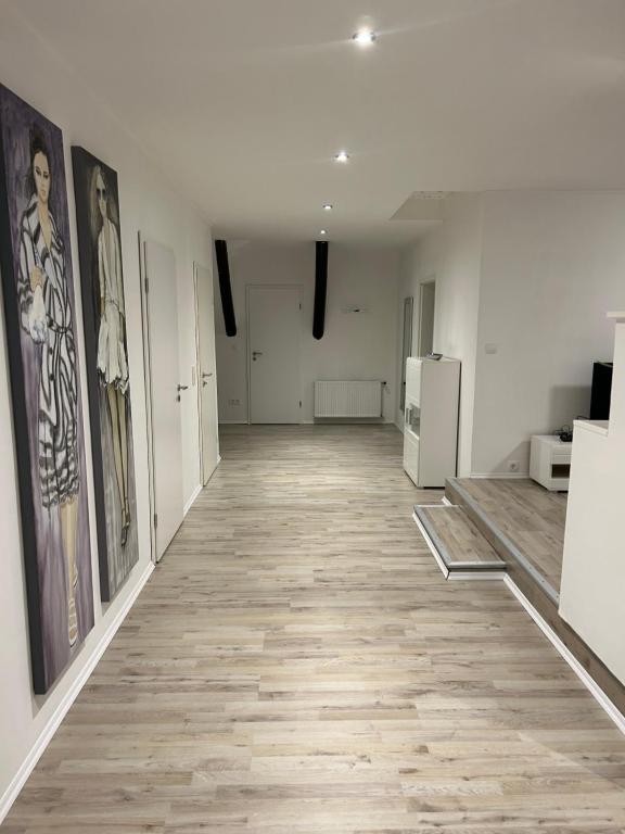 勒讷Wohnen wie zu Hause的一间空房间,墙上和走廊上都装饰有绘画作品