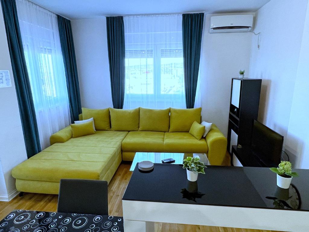 贝尔格莱德Pleasure Lux1 Apartment的客厅设有黄色沙发和电视