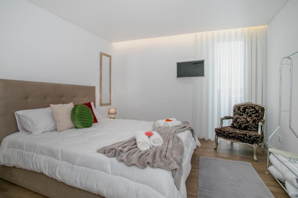 蓬塔德尔加达City Glow House的卧室配有白色的床和椅子