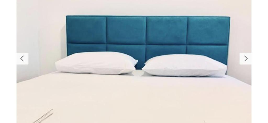 布德瓦Monte Star apartments的床上的2个枕头和蓝色床头板
