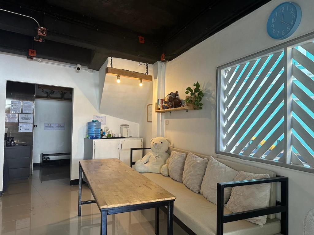 皮皮岛Blue Flow Hostel的客厅配有沙发、桌子和泰迪熊