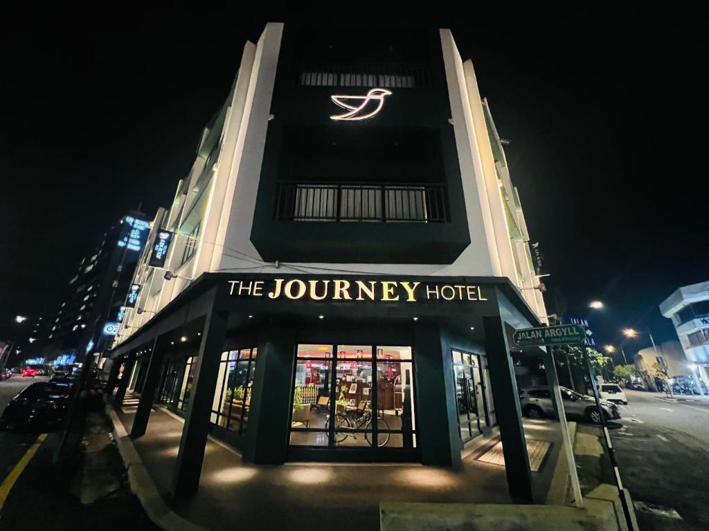 乔治市The Journey hotel的一座建筑,上面有夜间旅行酒店的标志