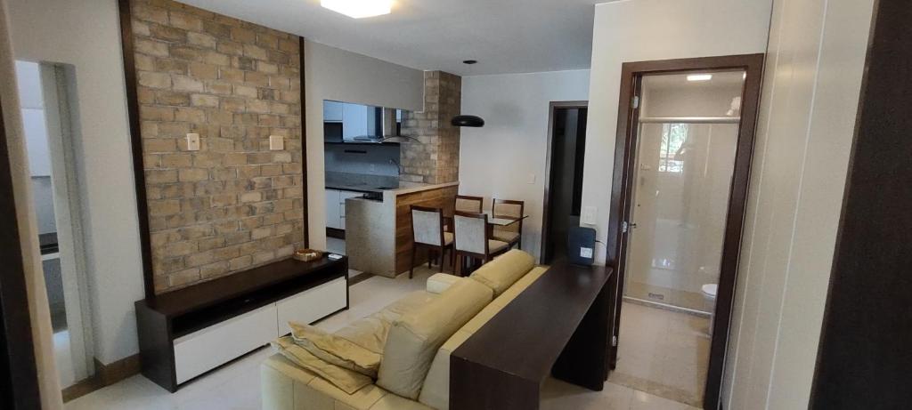 巴西利亚The Sun Resort - Super Apartamento de 2 quartos - 1 suíte e 1 reversível的带沙发和砖墙的客厅