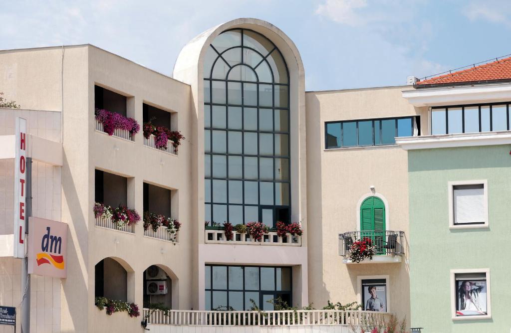 特罗吉尔Hotel Bellevue Trogir的一座带窗户和花箱的建筑,位于阳台上