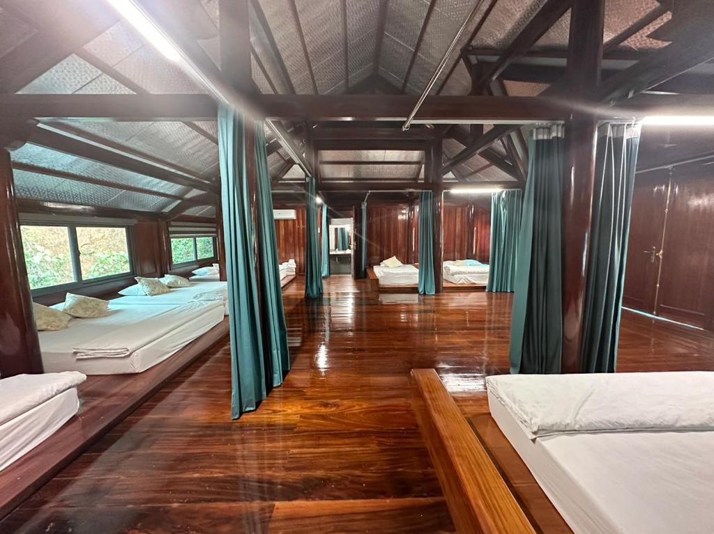 Hào Giakhách sạn thúy phương 2的客房设有三张床,铺有木地板。