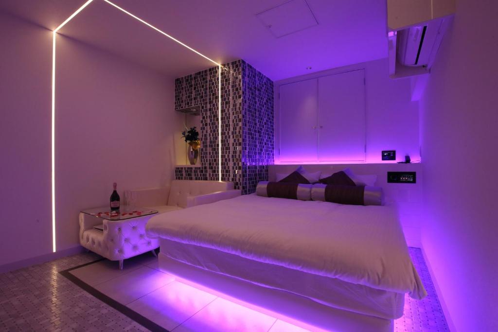 东京Hotel Blanche 大人専用的一间卧室配有白色床和紫色照明