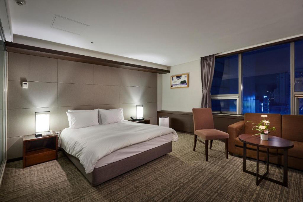 大田城际酒店的酒店客房,配有一张床、一张桌子和椅子