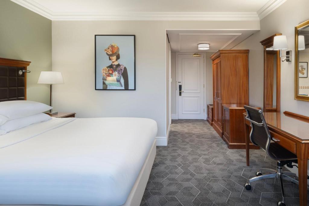 亨廷登Delta Hotels by Marriott Huntingdon的配有一张床和一张书桌的酒店客房