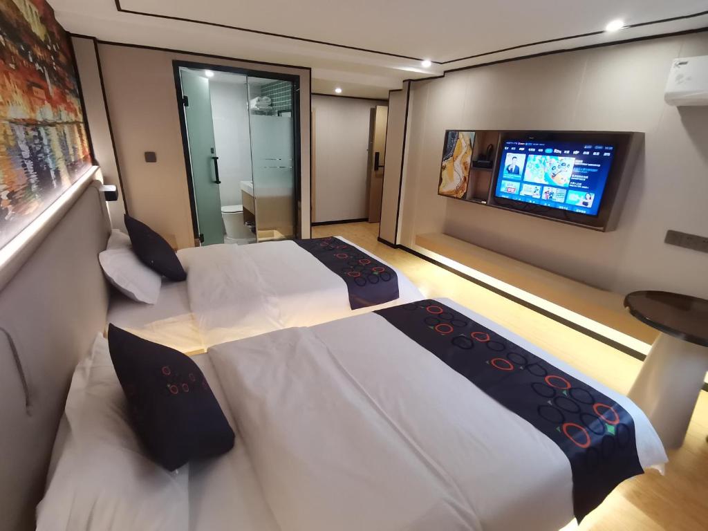 广州逸米米公寓(广州十三行一德路地铁站店)的一间卧室配有两张床和一台平面电视