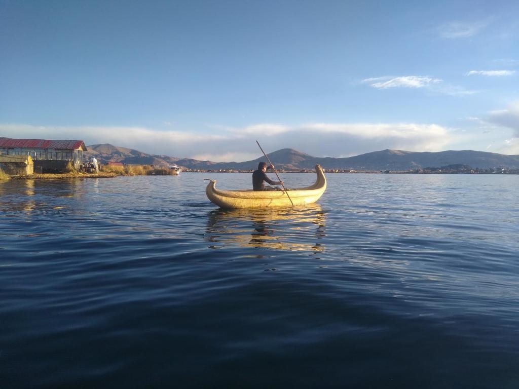 普诺Uros Titicaca Ayni lodge的水上划独木舟的人