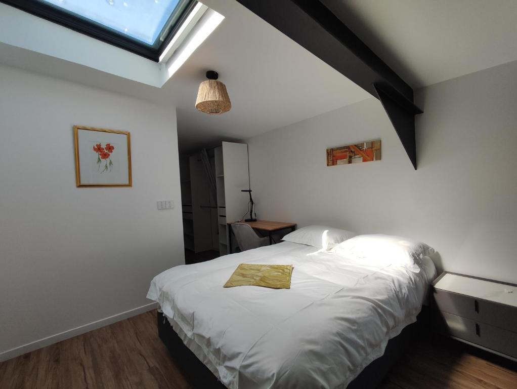 泰昂维COLIVING FLORALE的一间卧室配有一张带白色床单的床和一扇窗户。