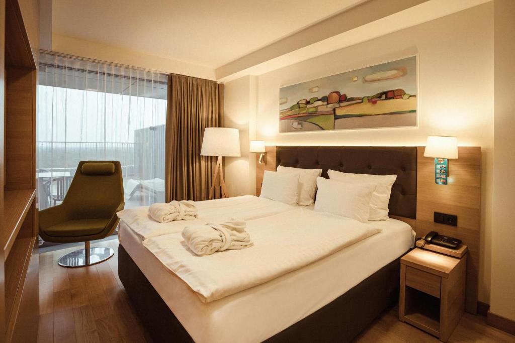 尤尔马拉斯玛拉里卢普SPA&会议酒店的酒店客房带一张大床和一把椅子