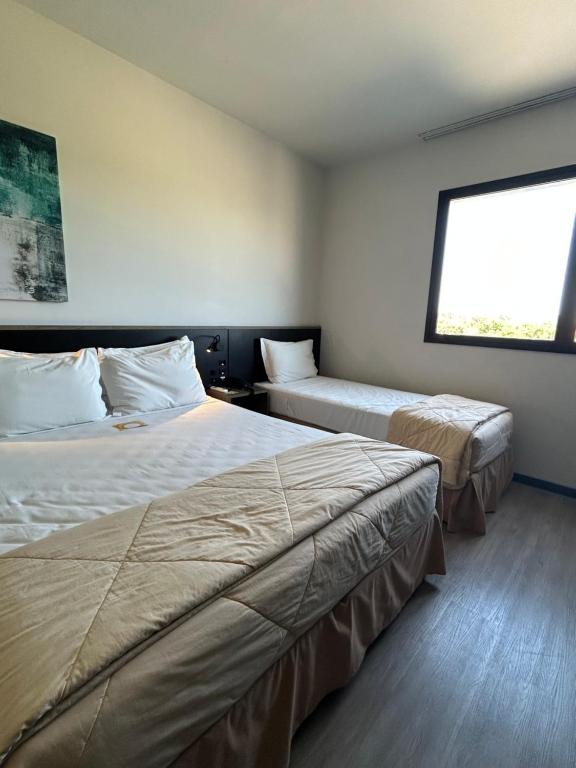 佩尼亚Solar Pedra da Ilha - Quarto 611的酒店客房设有两张床和窗户。