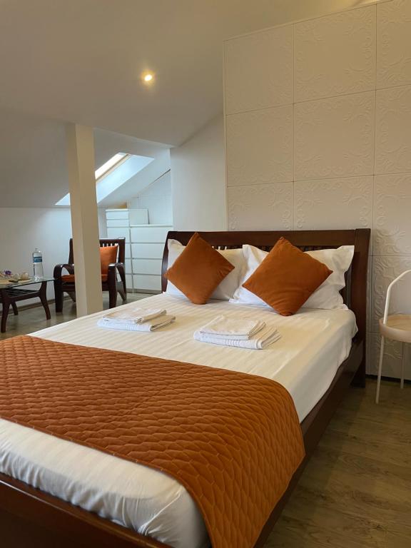 奥托佩尼Ami Residence Bucharest Airport&Therme&Parking的一间卧室配有一张带橙色枕头的大床